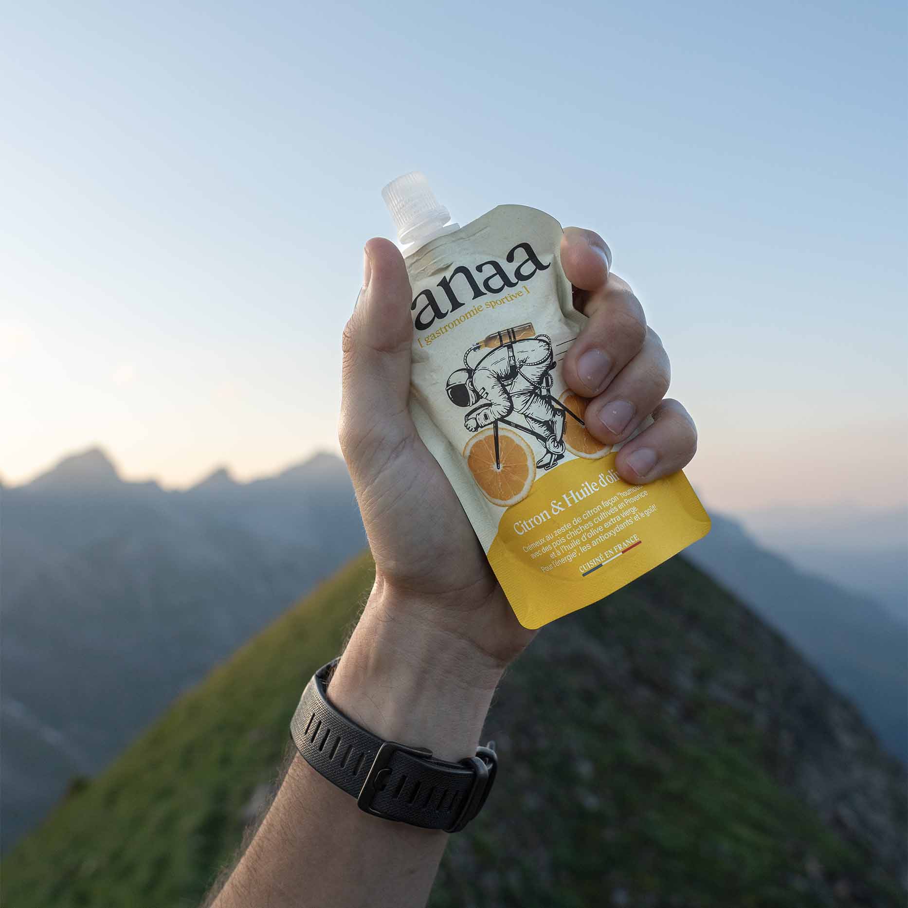 Main tenant le sachet Yanaa Citron & Huile d’olive en montagne France
