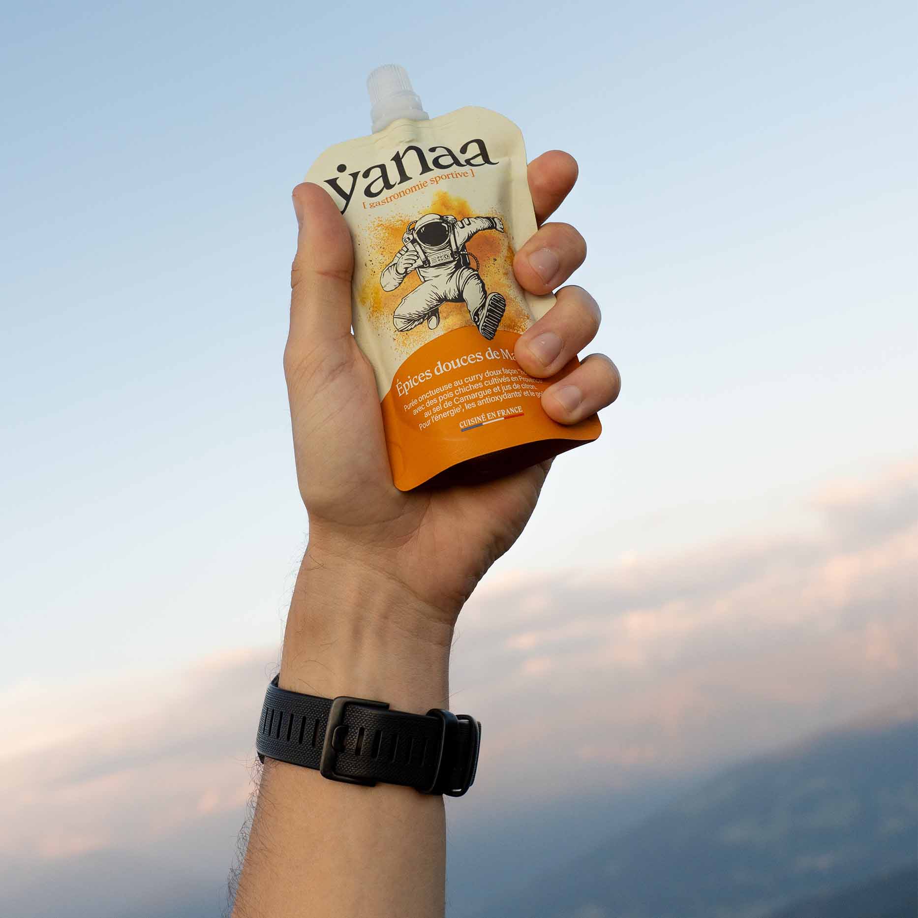 Main tenant le sachet Yanaa Épices douces de Madras en extérieur France